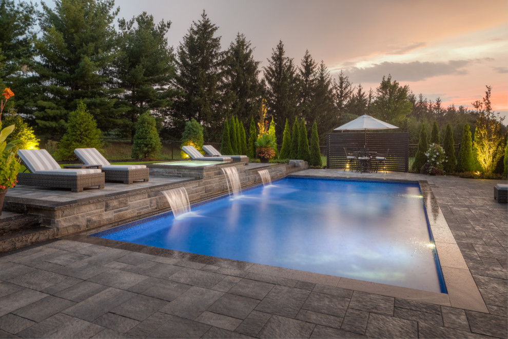 Pool landscaping - large transitional backyard brick and rectangular lap pool landscaping idea in Toronto