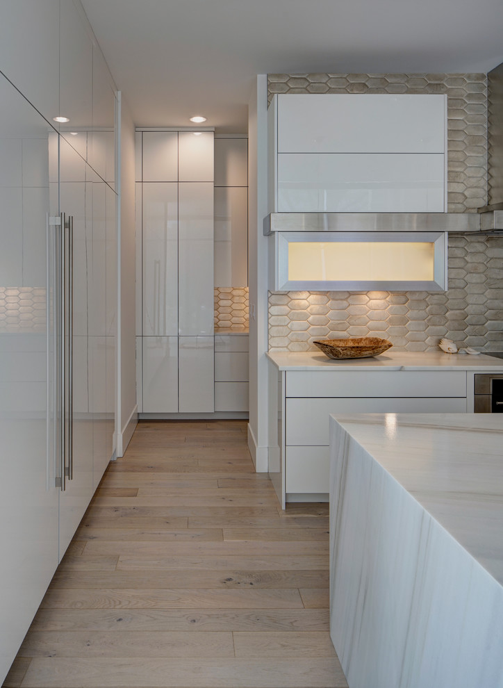 Inspiration for a large contemporary l-shaped eat-in kitchen in Chicago with an undermount sink, flat-panel cabinets, white cabinets, marble benchtops, metallic splashback, terra-cotta splashback, stainless steel appliances, light hardwood floors and with island.