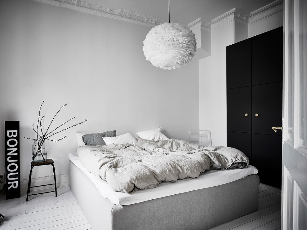 Photo of a scandinavian master bedroom in Gothenburg with white walls, painted wood floors, no fireplace and white floor.