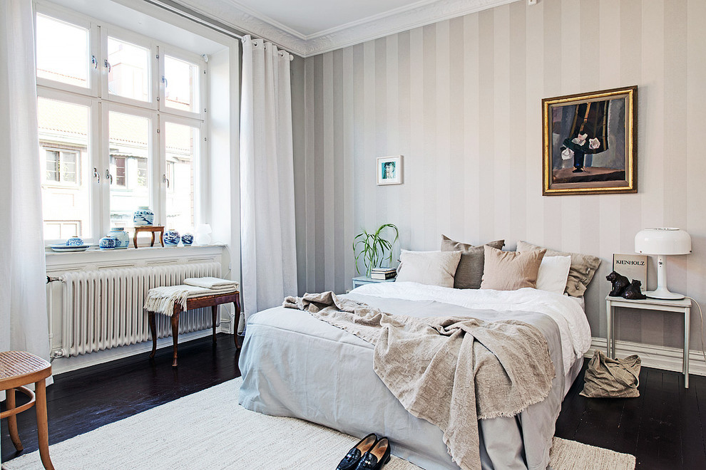 Mid-sized scandinavian master bedroom in Gothenburg with multi-coloured walls, dark hardwood floors and no fireplace.