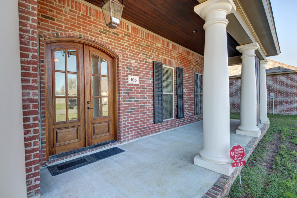Mid-sized traditional one-storey brick red exterior in New Orleans with a hip roof.