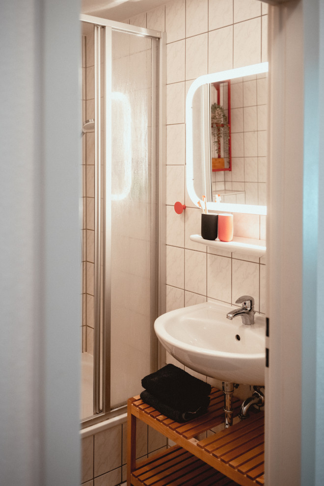 Cette image montre une salle d'eau grise et blanche nordique en bois clair de taille moyenne avec un placard sans porte, une douche d'angle, WC suspendus, un carrelage blanc, des carreaux de céramique, un mur gris, sol en stratifié, un lavabo suspendu, un plan de toilette en bois, un sol beige, une cabine de douche à porte coulissante, un plan de toilette beige, meuble simple vasque, meuble-lavabo suspendu, un plafond en papier peint et du papier peint.