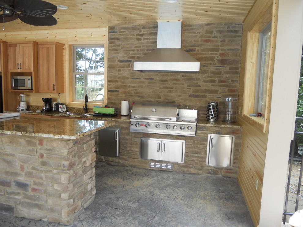 Inspiration for a mid-sized transitional backyard concrete patio kitchen remodel with a roof extension