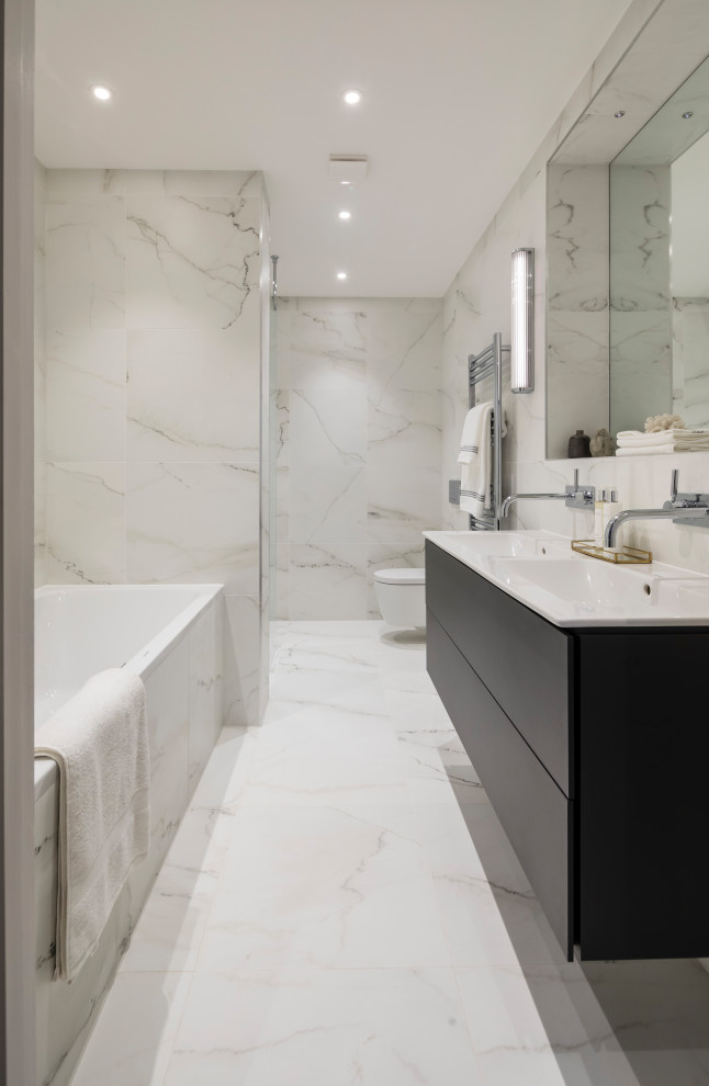 Design ideas for a large contemporary master bathroom in London with flat-panel cabinets, dark wood cabinets, an alcove tub, a wall-mount toilet, gray tile, porcelain tile, porcelain floors, an integrated sink, grey floor and white benchtops.