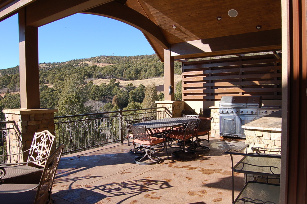 Large mountain style side yard outdoor kitchen deck photo in Denver with a roof extension