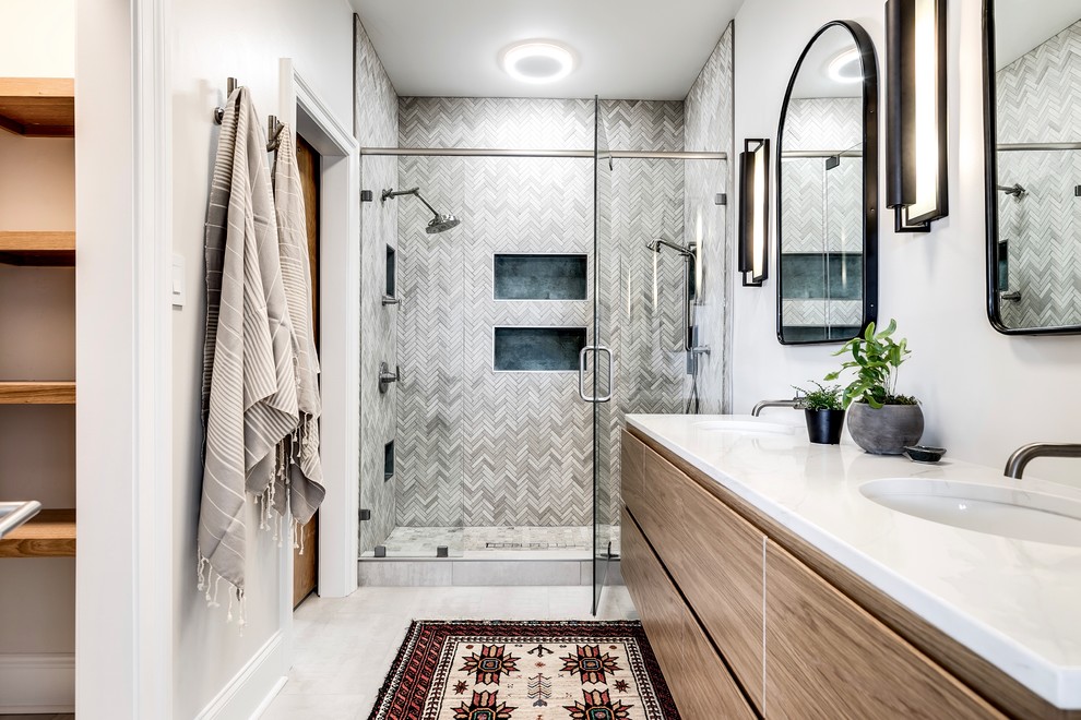 Photo of a transitional bathroom in Richmond with flat-panel cabinets, light wood cabinets, an alcove shower, gray tile, white walls, an undermount sink, white floor, a hinged shower door and white benchtops.