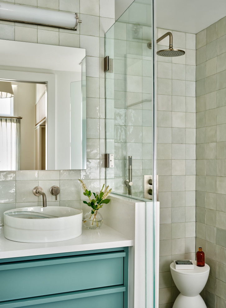 Пример оригинального дизайна: главная ванная комната в морском стиле с зелеными фасадами, угловым душем, унитазом-моноблоком, зеленой плиткой, керамической плиткой, белыми стенами, полом из керамогранита, настольной раковиной, столешницей из искусственного кварца, душем с распашными дверями, белой столешницей, тумбой под одну раковину, встроенной тумбой, панелями на стенах и плоскими фасадами