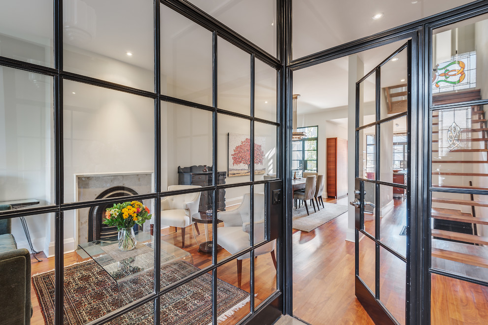 This is an example of a mid-sized industrial foyer in Toronto with white walls and light hardwood floors.