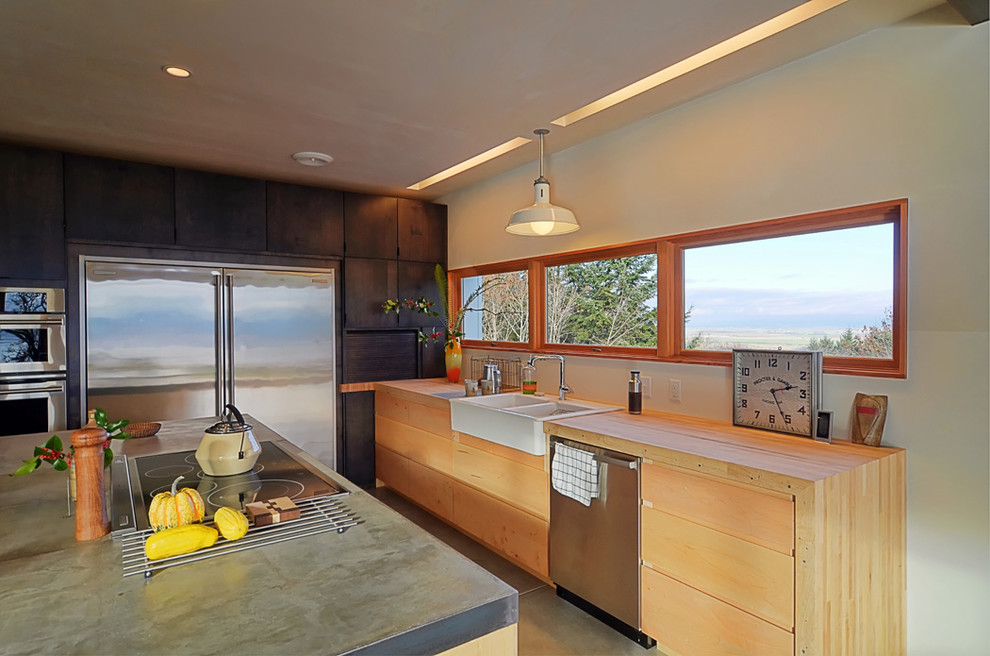 Photo of a contemporary kitchen in Portland with stainless steel appliances, a farmhouse sink and concrete benchtops.