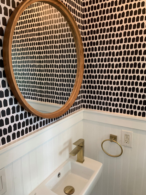 a small trendy dark wood floor, brown floor and wallpaper powder room design in New York with a two-piece toilet, white walls, a wall-mount sink and a floating vanity 