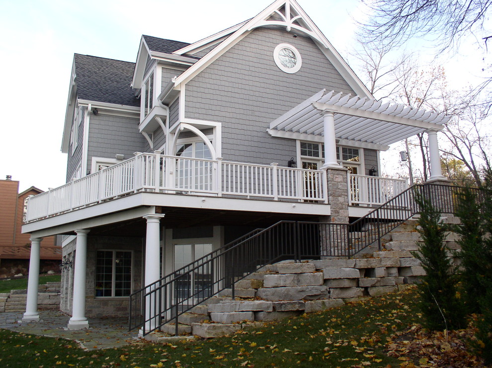 Photo of a large beach style three-storey grey exterior in Milwaukee with wood siding.