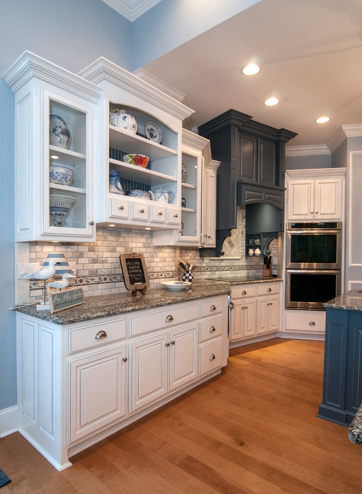This is an example of an expansive beach style kitchen in Charlotte with open cabinets, white cabinets, grey splashback, stainless steel appliances, light hardwood floors and with island.