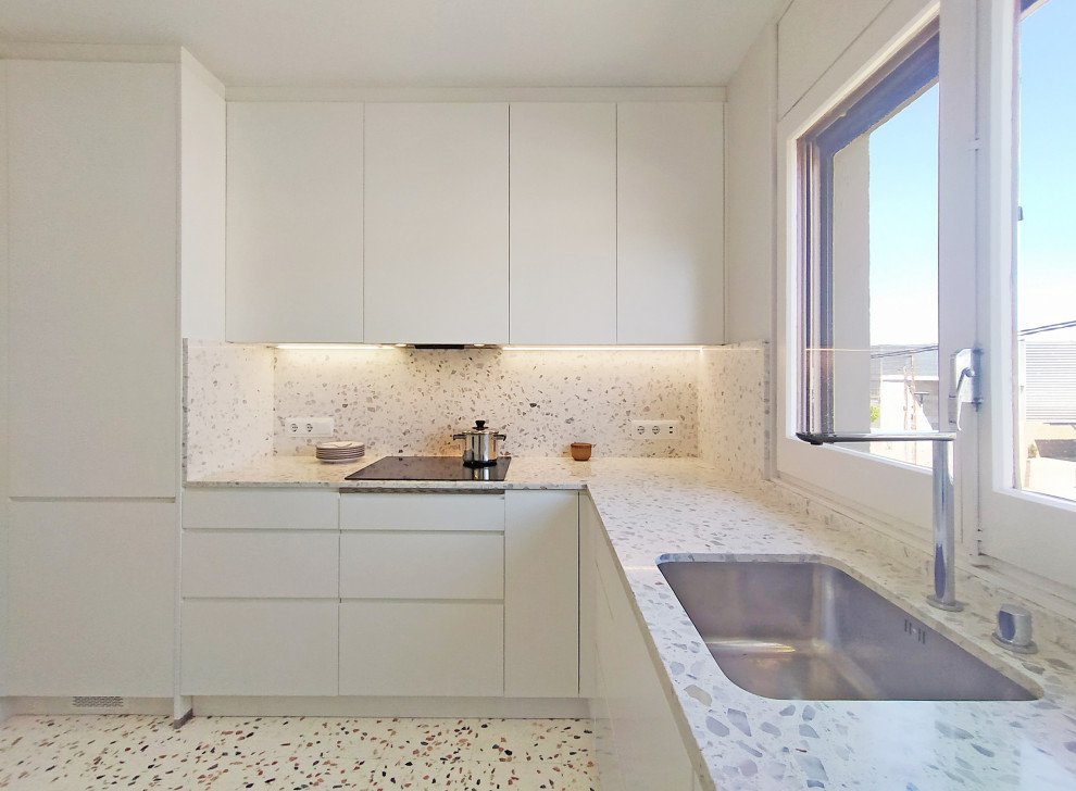 Inspiration for a small modern u-shaped separate kitchen in Barcelona with an undermount sink, flat-panel cabinets, white cabinets, terrazzo benchtops, grey splashback, granite splashback, panelled appliances, terrazzo floors, no island, multi-coloured floor and grey benchtop.