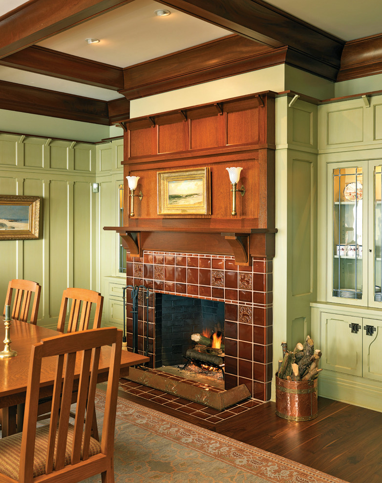 Inspiration for a large arts and crafts separate dining room in Providence with green walls, dark hardwood floors, a standard fireplace and a tile fireplace surround.