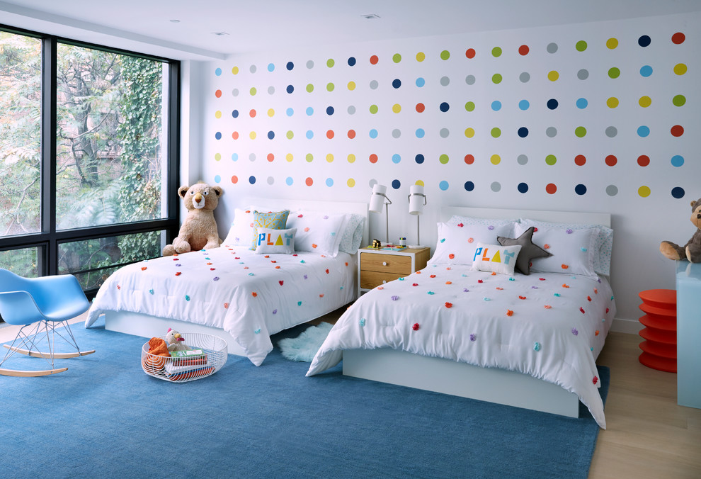 Photo of a mid-sized contemporary gender-neutral kids' bedroom for kids 4-10 years old in Other with white walls, light hardwood floors and beige floor.