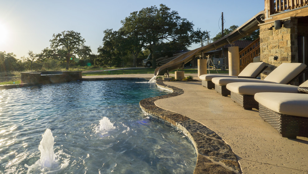 Large mountain style backyard stone and custom-shaped pool fountain photo in Austin