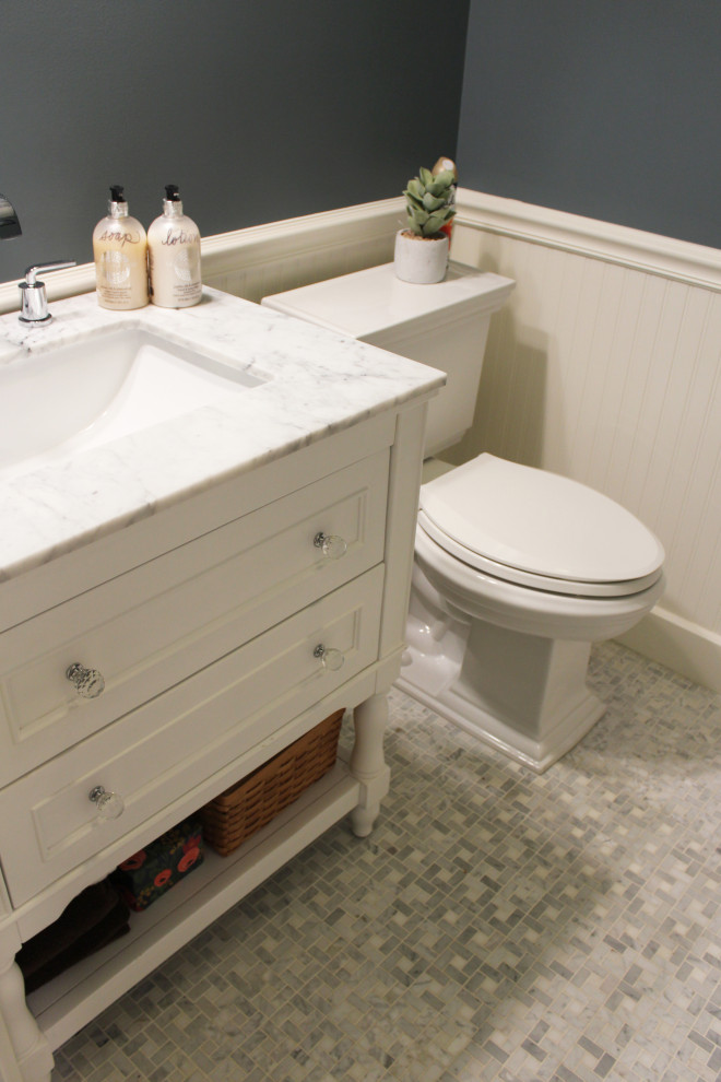 Inredning av ett modernt litet vit vitt toalett, med möbel-liknande, vita skåp, en toalettstol med separat cisternkåpa, blå väggar, klinkergolv i porslin, ett undermonterad handfat, bänkskiva i kvartsit och vitt golv