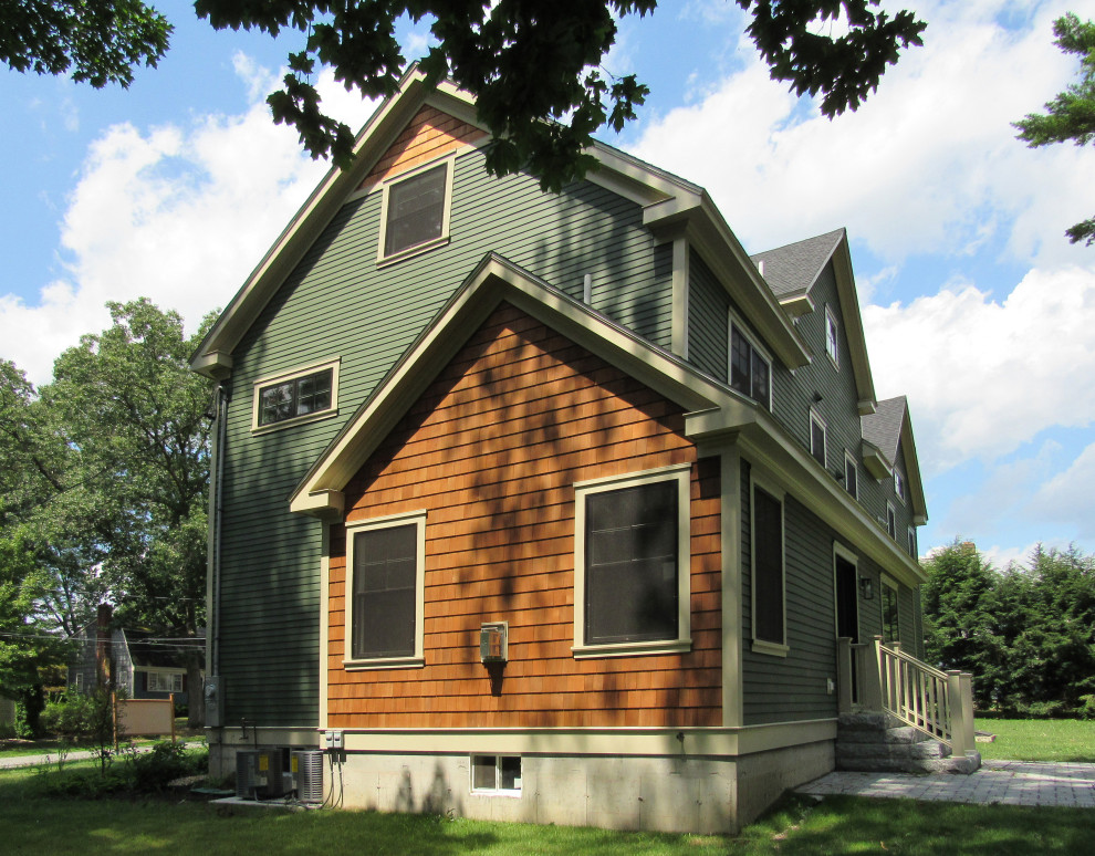 Large modern two-storey green house exterior in Boston with mixed siding, a gable roof and a shingle roof.