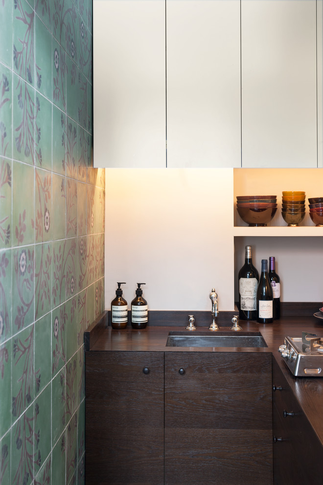 Inspiration for a small eclectic l-shaped separate kitchen in London with an undermount sink, flat-panel cabinets, dark wood cabinets, wood benchtops, grey splashback, stainless steel appliances and concrete floors.