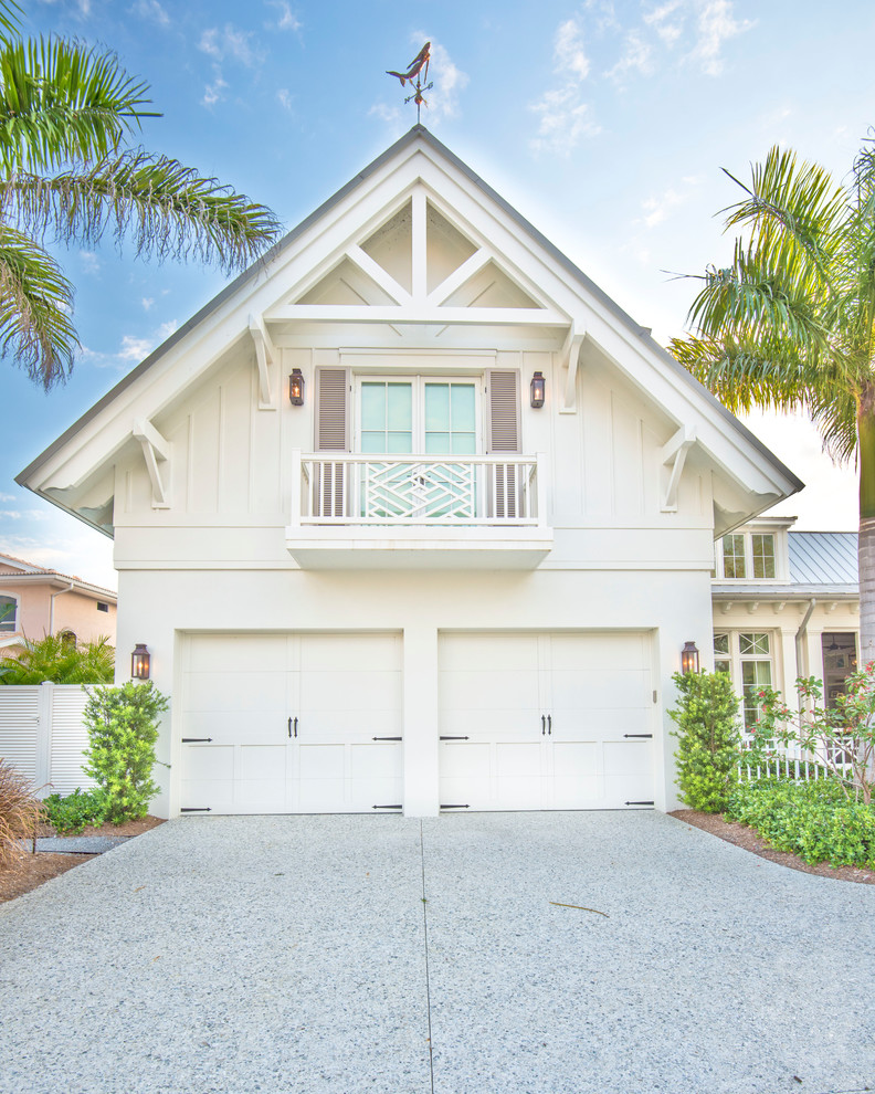 Large tropical two-storey white house exterior in Tampa with a gable roof, concrete fiberboard siding and a metal roof.