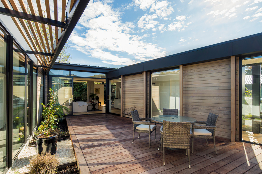 Design ideas for a contemporary courtyard patio in Christchurch with decking and a pergola.