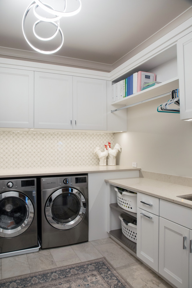 Large transitional u-shaped utility room in Milwaukee with an undermount sink, flat-panel cabinets, white cabinets, quartz benchtops, beige splashback, engineered quartz splashback, white walls, porcelain floors, a side-by-side washer and dryer, beige floor and beige benchtop.