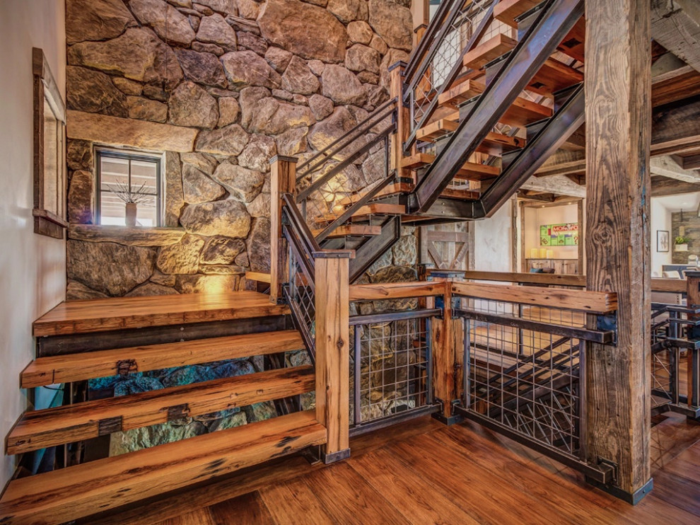 Foto de escalera rural con escalones de madera y barandilla de metal
