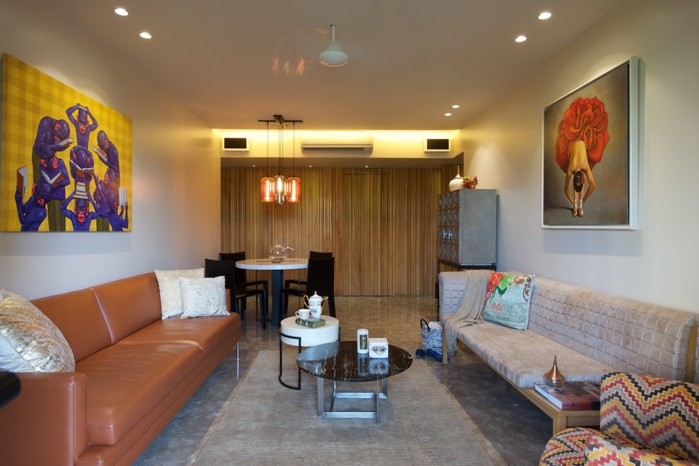 This is an example of a contemporary open concept living room in Mumbai with white walls and grey floor.