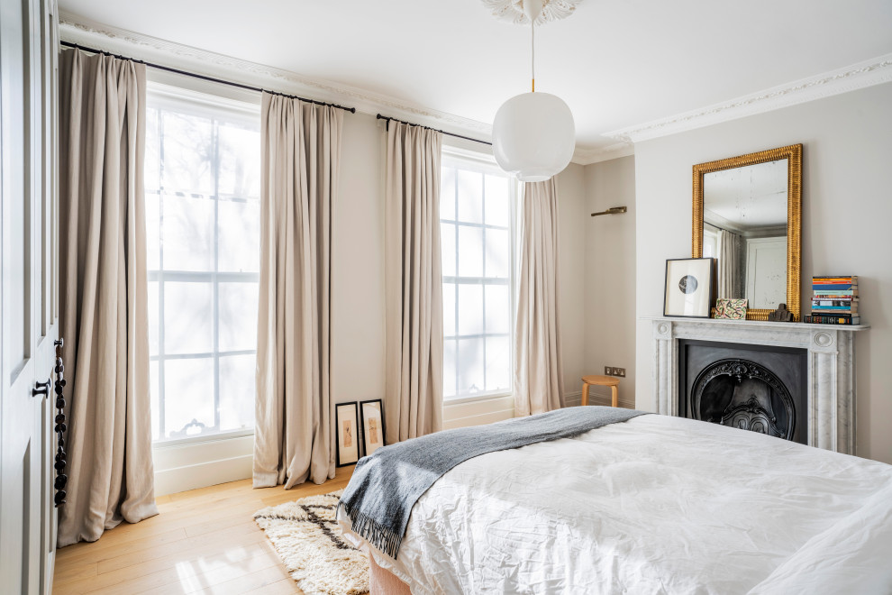 This is an example of a victorian bedroom in London with white walls, light hardwood flooring and brown floors.