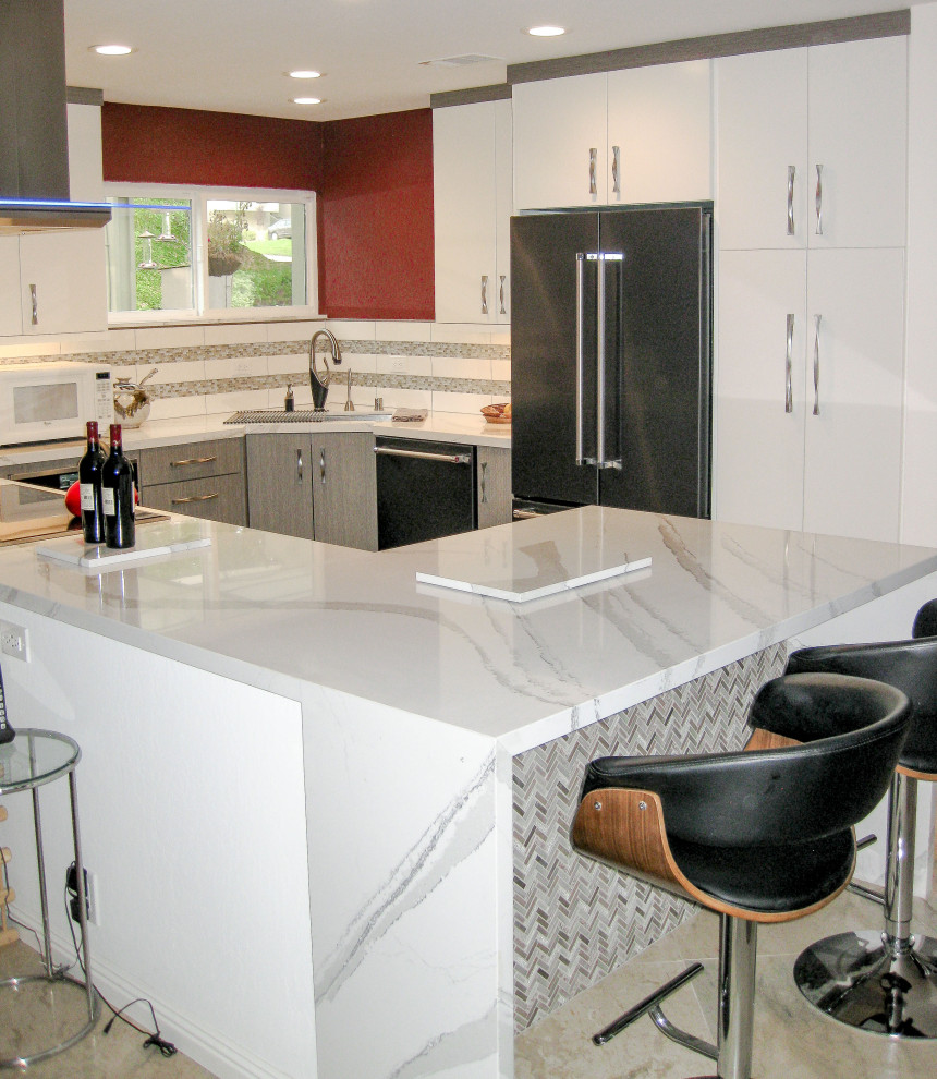 Example of a mid-sized trendy u-shaped vinyl floor and gray floor open concept kitchen design in San Francisco with a single-bowl sink, flat-panel cabinets, gray cabinets, quartz countertops, white backsplash, glass tile backsplash, stainless steel appliances, a peninsula and white countertops
