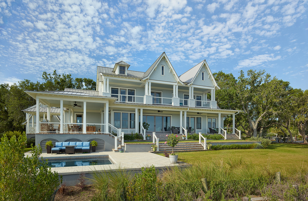 Inspiration for a large beach style three-storey blue house exterior in Charleston with concrete fiberboard siding, a gable roof and a metal roof.