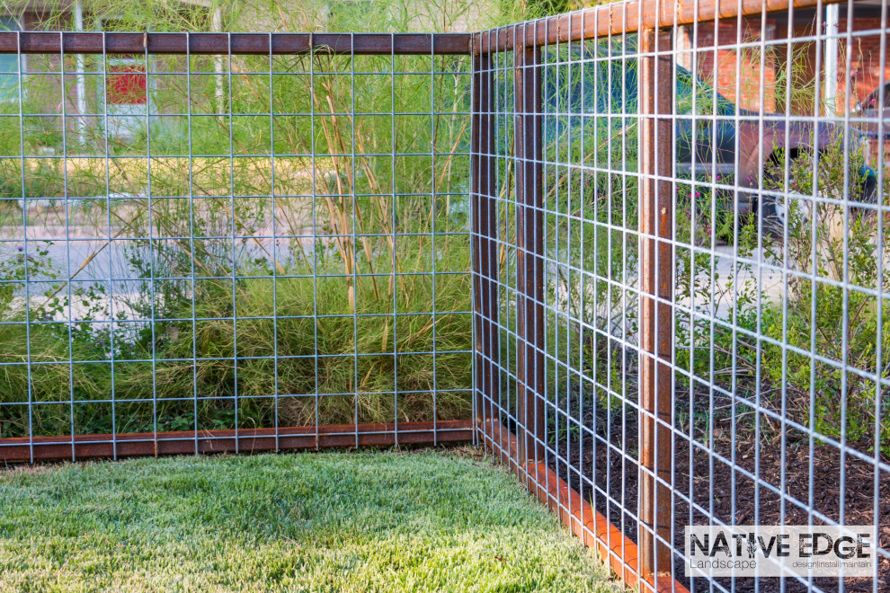 Idee per un giardino xeriscape moderno esposto a mezz'ombra di medie dimensioni e davanti casa in estate con pavimentazioni in pietra naturale e recinzione in metallo