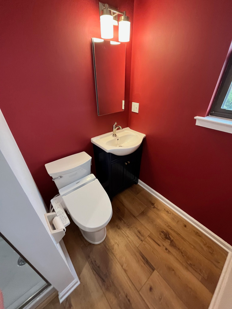 Esempio di un piccolo bagno di servizio minimalista con ante in stile shaker, ante blu, bidè, pareti rosse, pavimento in bambù, lavabo integrato, top in superficie solida, top bianco e mobile bagno freestanding