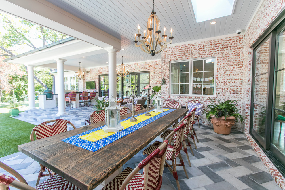 Large eclectic backyard patio in Dallas with an outdoor kitchen, concrete pavers and a roof extension.