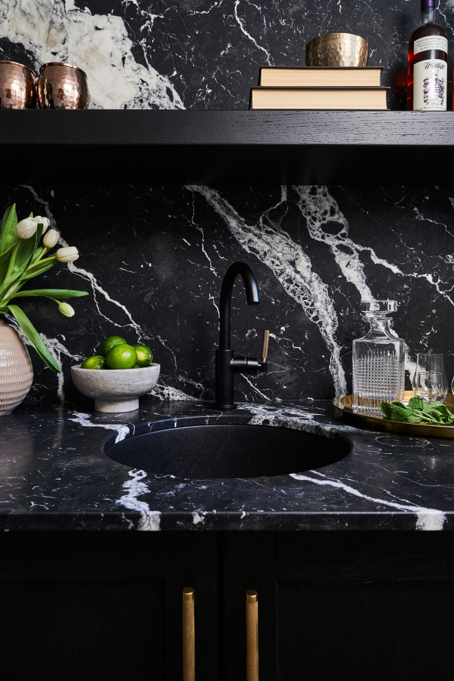 Design ideas for a transitional home bar in Toronto with an undermount sink, marble benchtops, black splashback, marble splashback and black benchtop.