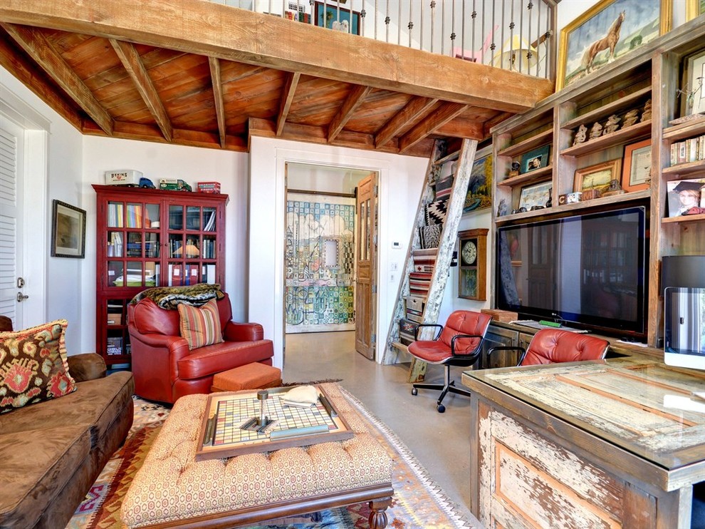 Photo of a large eclectic study room in Austin with white walls, concrete floors, a built-in desk and grey floor.
