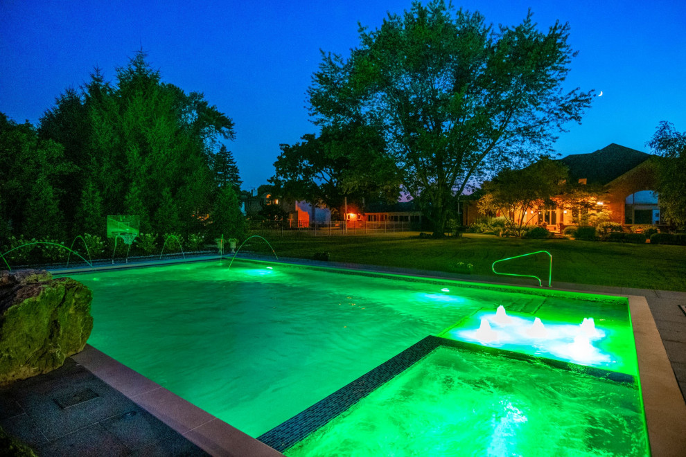Photo of a mid-sized traditional backyard rectangular lap pool in Chicago with with a pool and natural stone pavers.