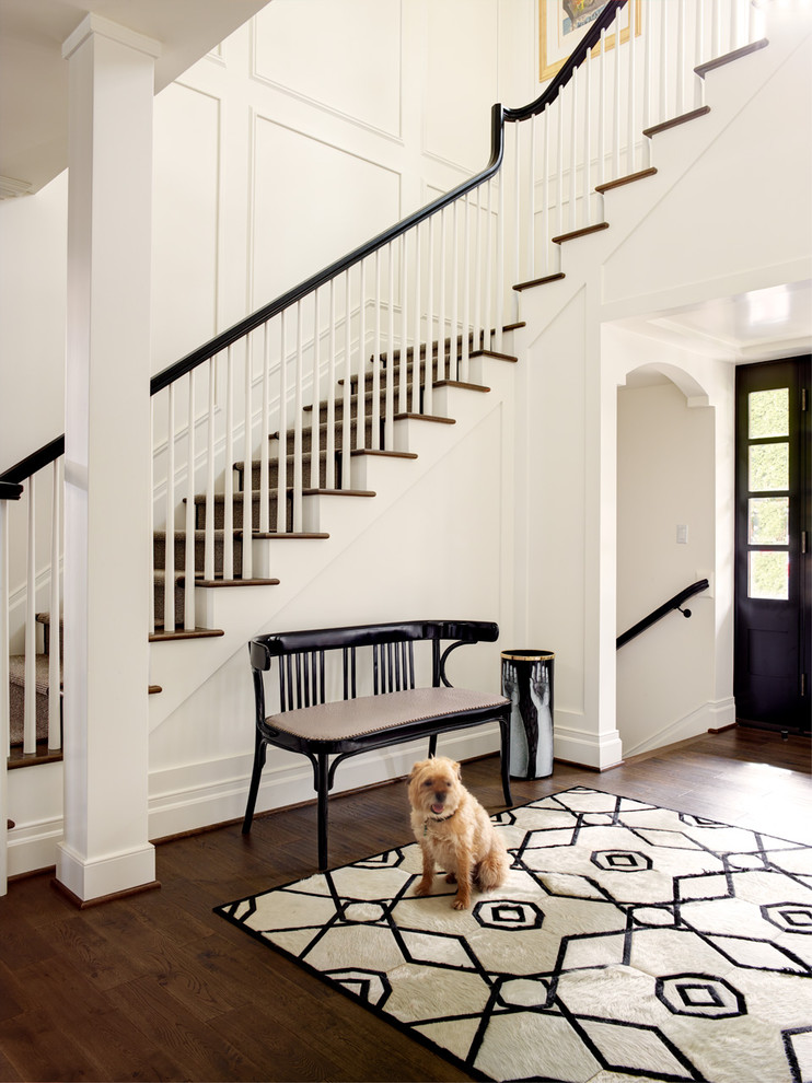 Design ideas for a transitional foyer in Seattle with white walls, dark hardwood floors, a black front door and brown floor.