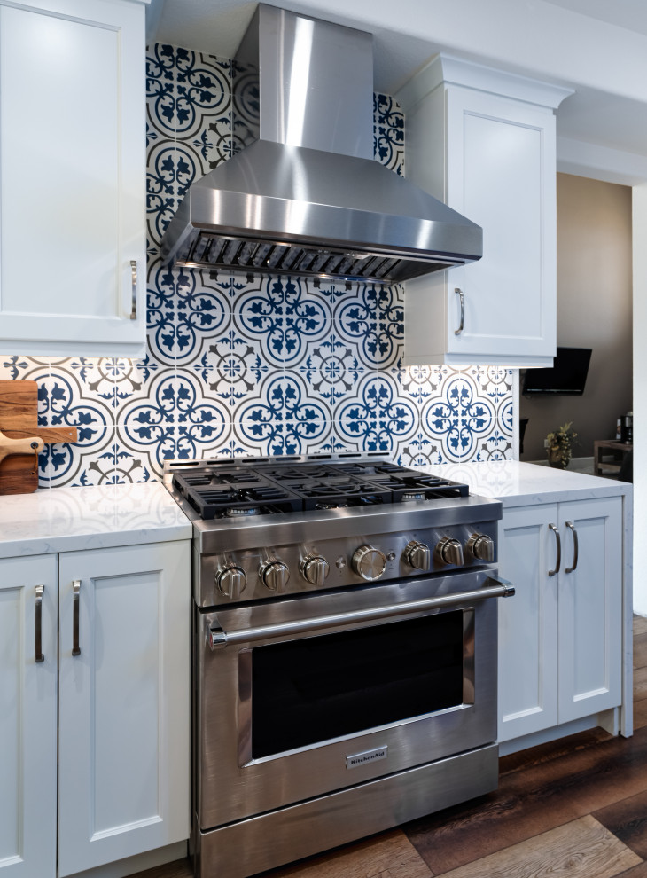 Ispirazione per una cucina classica di medie dimensioni con lavello stile country, ante lisce, ante bianche, top in quarzo composito, paraspruzzi blu, paraspruzzi con piastrelle a mosaico, elettrodomestici neri, pavimento in legno massello medio, pavimento multicolore, top bianco e soffitto ribassato