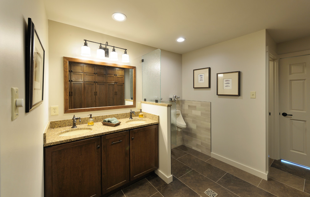 This is an example of a mid-sized traditional master bathroom in Other with recessed-panel cabinets, medium wood cabinets, beige tile, porcelain tile, white walls, porcelain floors, an undermount sink, granite benchtops, brown floor, an open shower, an urinal and an open shower.