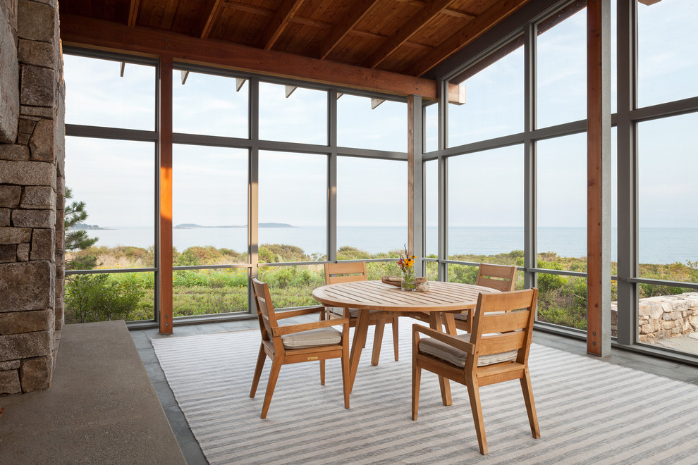 Inspiration for a large contemporary backyard screened-in verandah in Portland Maine with natural stone pavers and a roof extension.