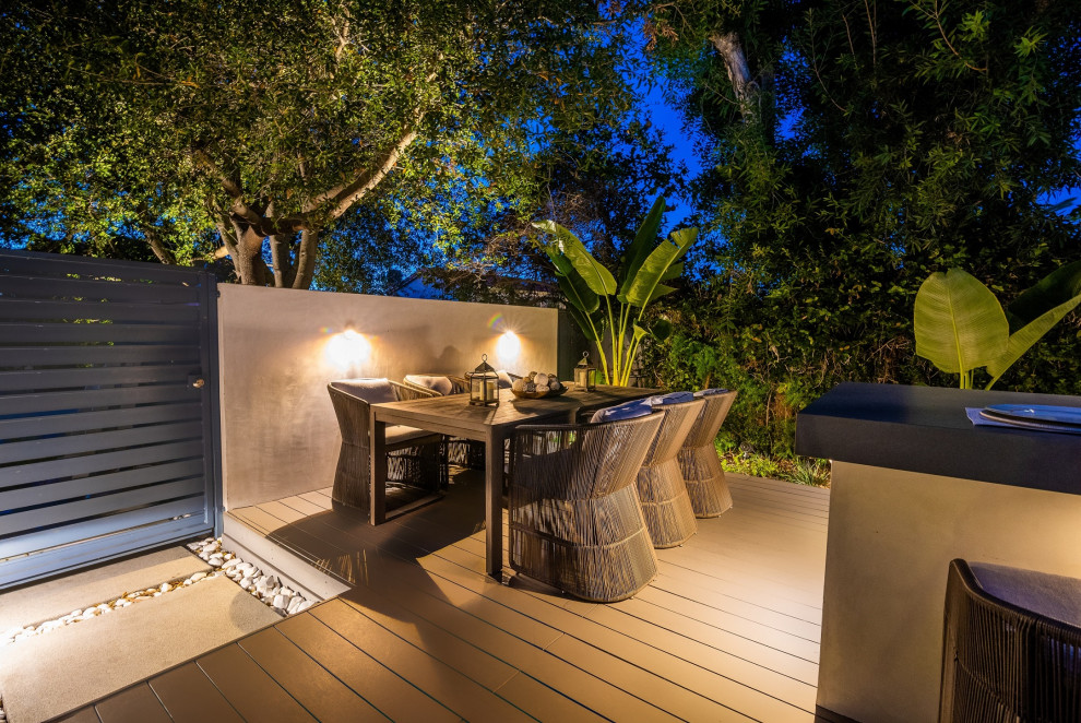 This is an example of a mid-sized contemporary backyard patio in Orange County with an outdoor kitchen and decking.