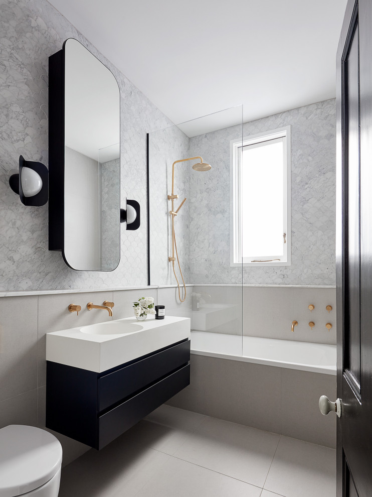 This is an example of a mid-sized contemporary 3/4 bathroom in Melbourne with flat-panel cabinets, black cabinets, a wall-mount toilet, gray tile, an integrated sink, grey floor, white benchtops, a single vanity and a floating vanity.