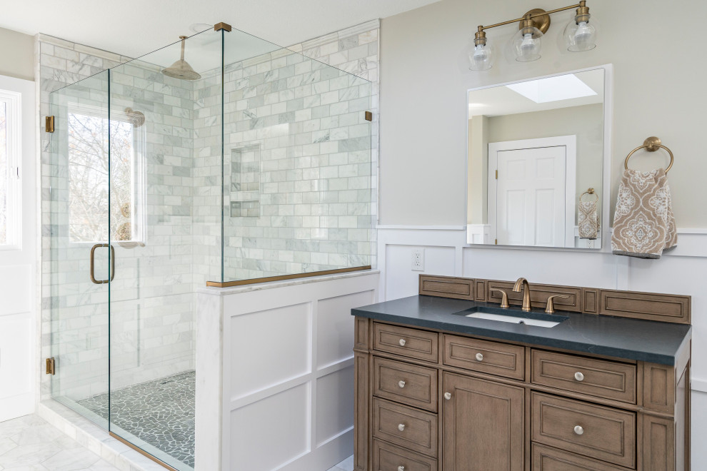 This is an example of a transitional 3/4 bathroom in Other with recessed-panel cabinets, medium wood cabinets, an alcove shower, multi-coloured tile, subway tile, beige walls, an undermount sink, multi-coloured floor, a hinged shower door, black benchtops, a single vanity, a built-in vanity and decorative wall panelling.
