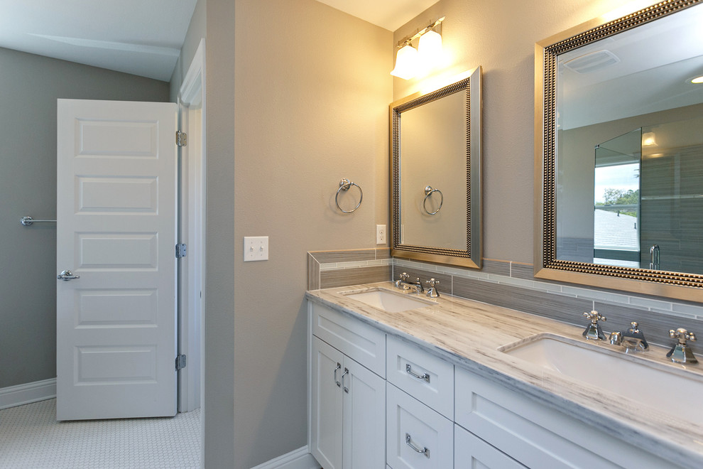 Mid-sized arts and crafts master bathroom in Portland with an undermount sink, recessed-panel cabinets, white cabinets, marble benchtops, a drop-in tub, an alcove shower, gray tile, porcelain tile, grey walls and porcelain floors.