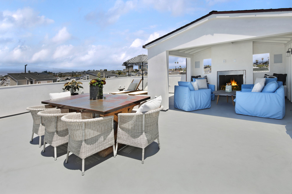 Photo of a large beach style rooftop deck in Orange County with with fireplace and no cover.