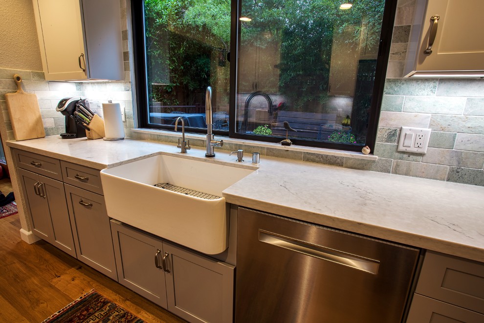 Inspiration for a large transitional galley light wood floor and brown floor open concept kitchen remodel in Sacramento with a farmhouse sink, shaker cabinets, gray cabinets, quartz countertops, gray backsplash, stone tile backsplash, stainless steel appliances, no island and white countertops