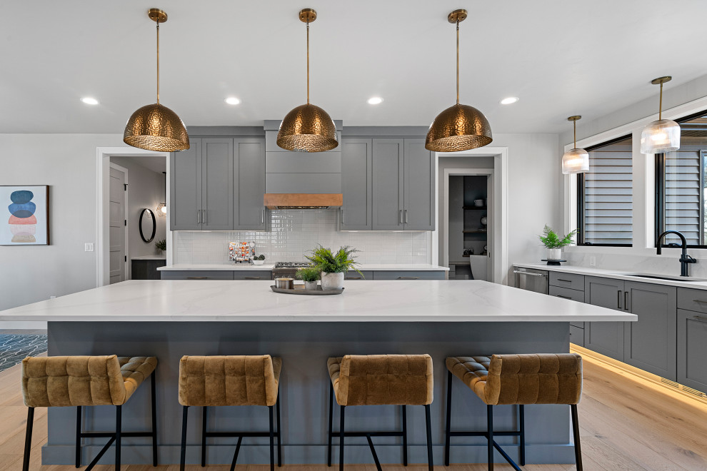 Kitchen - kitchen idea with recessed-panel cabinets, gray cabinets, quartz countertops and an island