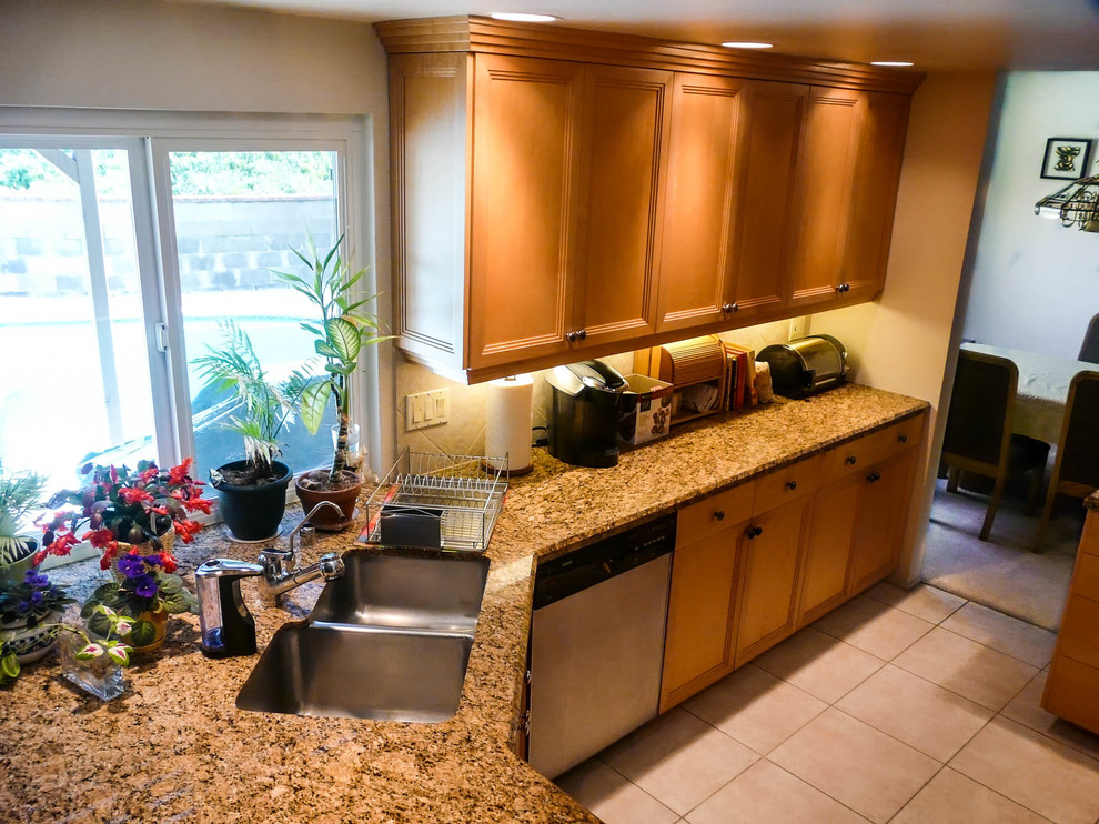Enclosed kitchen - mid-sized transitional l-shaped porcelain tile enclosed kitchen idea in San Diego with an undermount sink, recessed-panel cabinets, light wood cabinets, granite countertops, beige backsplash, porcelain backsplash, stainless steel appliances and no island