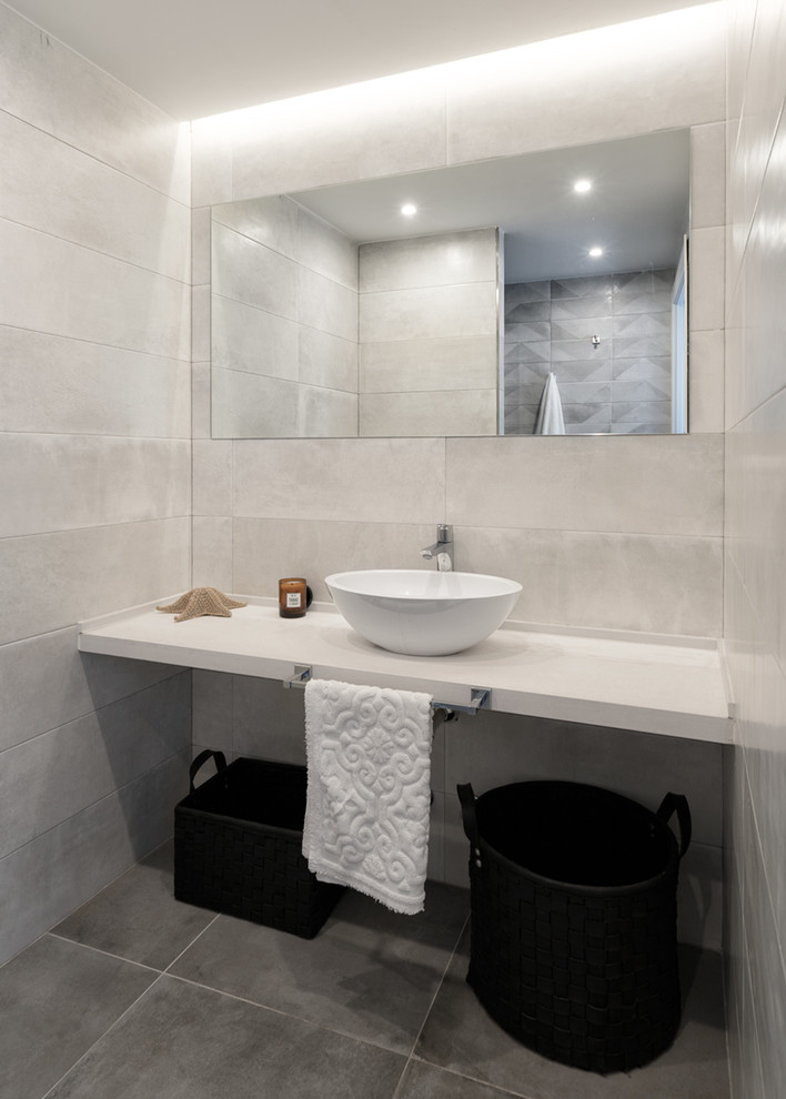 Photo of a mid-sized modern 3/4 bathroom in Other with open cabinets, white cabinets, a curbless shower, a one-piece toilet, gray tile, ceramic tile, grey walls, cement tiles, a vessel sink, wood benchtops, grey floor and a hinged shower door.